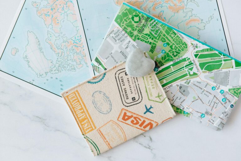 An overhead view of a passport holder on top of maps, symbolizing travel and exploration.